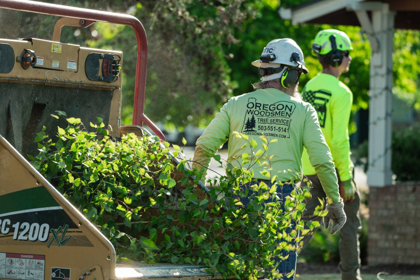 Oregon Woodsmen crew feeding brush into the chipper