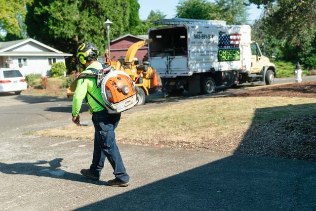 Crew member blowing the street clean after the job