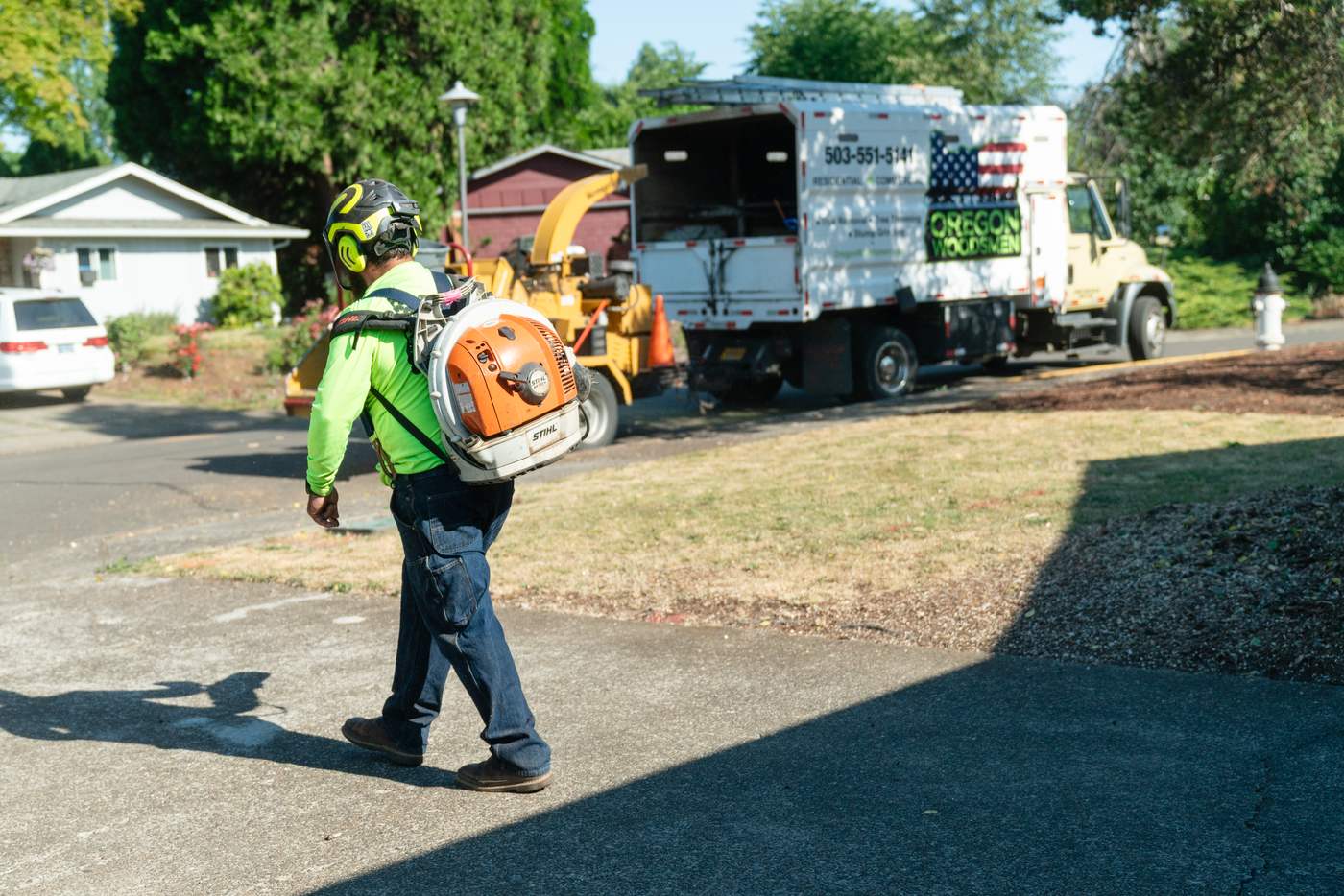 Crew member blowing the street clean after a job